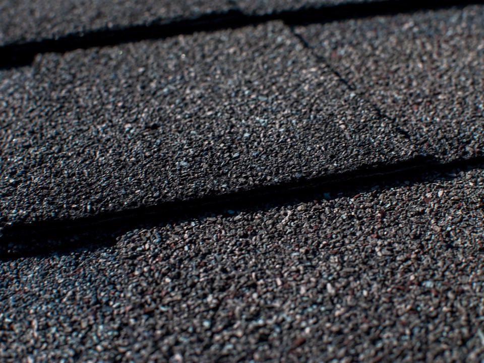 Close-up of granulated dark asphalt shingle courses